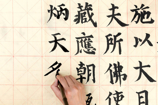 Woman painting Chinese symbols