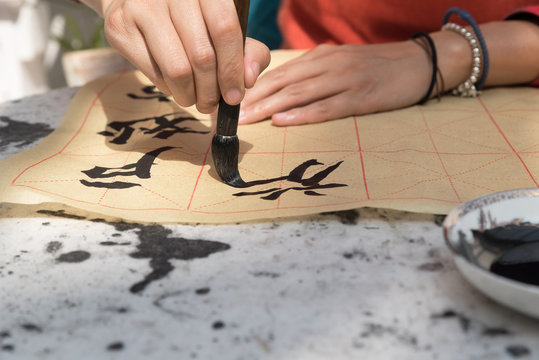 Woman painting Chinese symbols