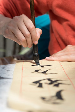 Woman painting Chinese symbols