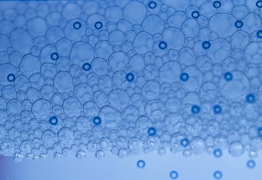 Bubbles in macro view of a micellar water through a blue filter