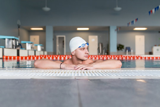 Young swimmer floating in pool at edge