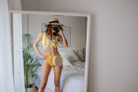Woman doing a selfie in the mirror in a bikini