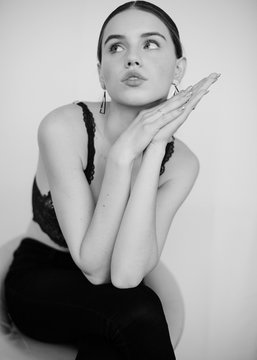 The portrait of a girl with triangle earrings and open mouth in bra thinking about something