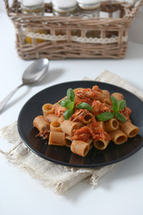 pasta with tomato sauce and mackerel garnished with basil leaf