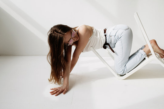 Stylish woman crawling with chair