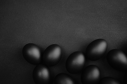 Black eggs on a black background. Easter minimalistic concept
