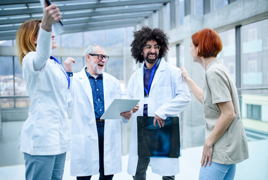 Group Of Doctors Standing On Conference, Medical Team Laughing.