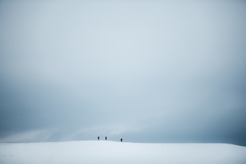 People hiking on snow covered glacier plateau