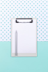 Mockup with white card. Clipboard with sheet of blank paper and silver pencil. Top view. Copy space.