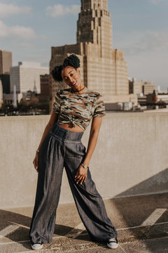 A beautiful African American girl in her twenties having fun against a city skyline