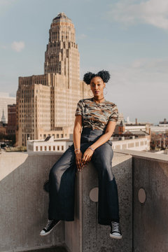 A beautiful African American girl in her twenties having fun against a city skyline
