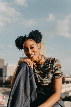 A beautiful African American girl in her twenties having fun against a city skyline