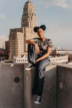 A beautiful African American girl in her twenties having fun against a city skyline