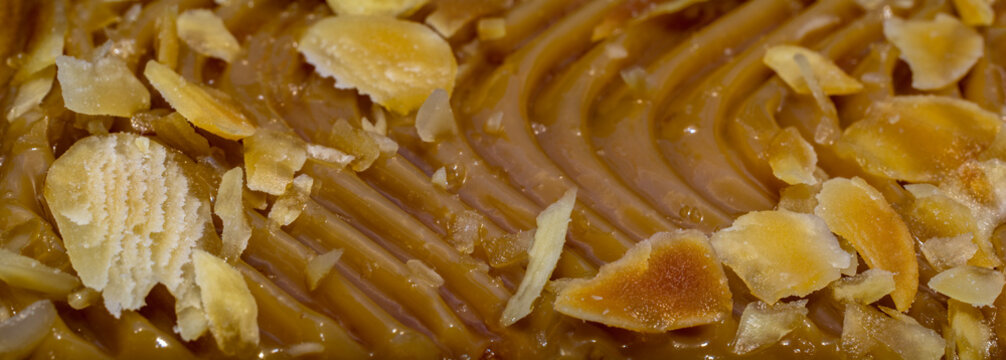 Panoramic view of macro toffee sprinkled with almonds