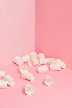 Many empty white to go coffee cups on pink.