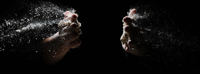 hands flapping flour in the dark. the flour is flying