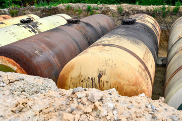 Large tanks in the excavated quarry for storage of petroleum products. Background
