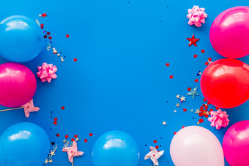 Party concept. Colorful balloons and confetti on blue background top-down frame copy space