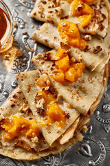 Hot sweet pancakes with peach on old fashioned grey metal tray. Dark backround. Food concept.