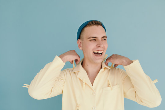 Cheerful man removing pegs from shirt