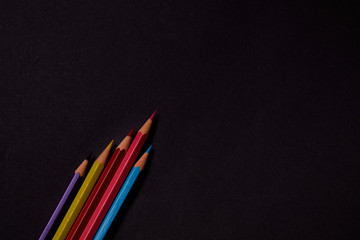 Multi colored crayons at black background with copy space	