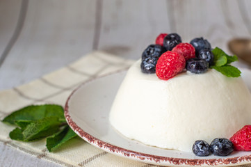 panna cotta, dairy gelatine dessert decorated with berries on white background 