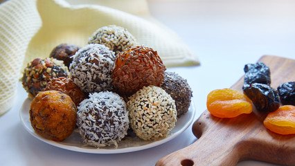 energy balls close-up. Raw, vegan, wholesome food with nuts, chia seeds, sesame seeds, flax, coconut flakes and dried fruits, prunes and dried apricots