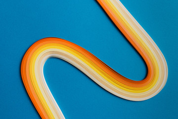 Multi colored quilling paper lying on colorful paper