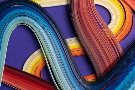 Multi colored quilling paper lying on colorful paper