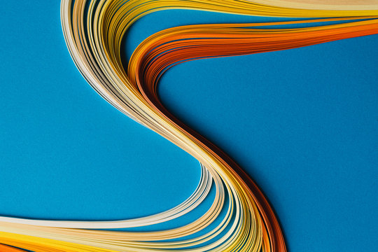 Multi colored quilling paper lying on colorful paper