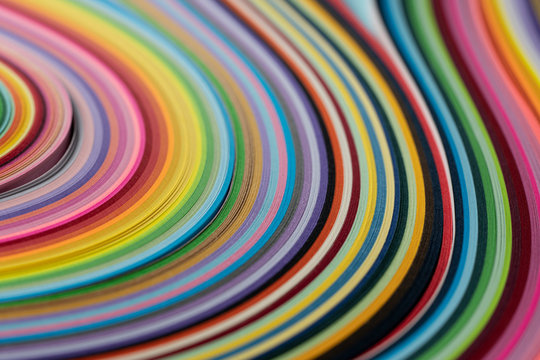Multi colored quilling paper lying on colorful paper