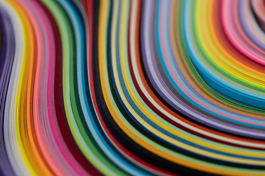 Multi colored quilling paper lying on colorful paper