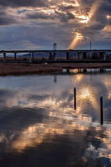 Stunning Light Shaft Illuminates Highway and Bridge over River