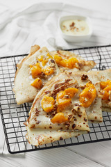 Hot sweet pancakes with peach on wooden table. White backround. Food concept.