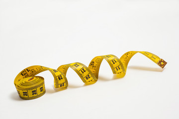 yellow tape measure on a white background for measuring clothing and body