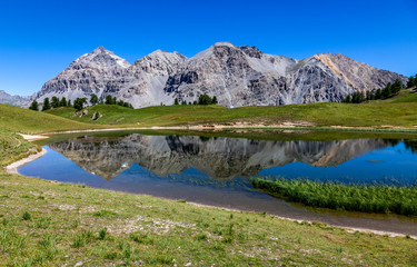 Le Rois Mages (Baltazar 3153m, Melchior 2948 m, Gaspard 2808 m , Quatre Soeurs 2587 m) and their reflection in the lake Chavillon on Etroite Valley- Hautes-Alpes.