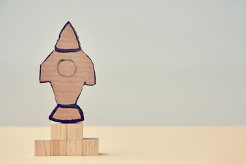 Start up or Rocket launch mockup. Start new life, challenge copy space. Business creativity. Spaceship on wooden cubes