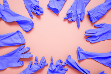 bunch of light purple medical rubber gloves placed as a frame for copy text on pink background