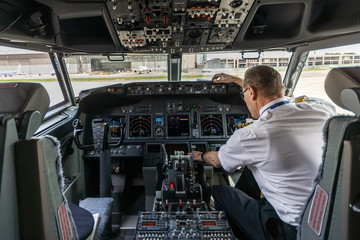Pilot in the cockpit of a passenger plane preparing aircraft for take-off