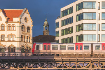 Germany, Hamburg, Elevated train with tower of Saint Michaels Church in background