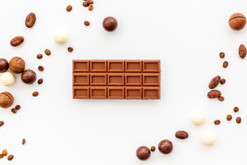 Candy background with chocolate on white table top view frame. Sweets desserts concept
