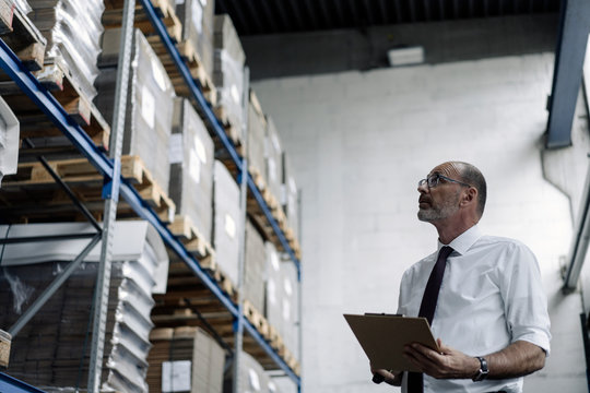 Man with clipboard in factory warehouse