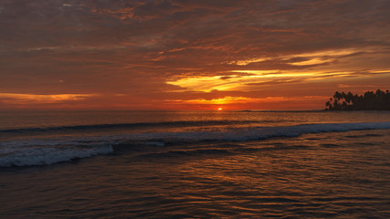 Sun goes down on amazing vivid sunset at the beach by the Indian ocean in Aceh, Indonesia