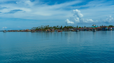 Balai village scene with stilted wooden houses and mosque in Banyak islands calm water