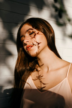 Portrait of teenage girl with shadow of leaves on her face