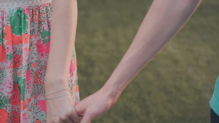 Slow motion .People walking along the road, holding hands . Intertwining fingers