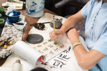  a man engaged in calligraphy sitting at a table