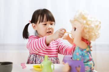 toddler girl pretend play feeding baby  at home