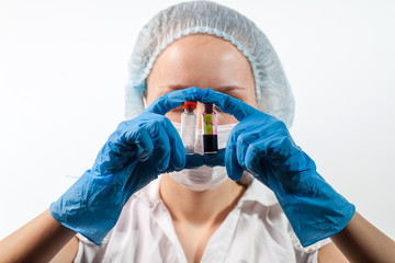 Fototapeta premium The doctor is wearing a respiratory mask with a positive blood test for a new rapidly spreading coronavirus SARS-CoV-2originating from Russia, Kommunarka. The doctor holds a test tube COVID-19