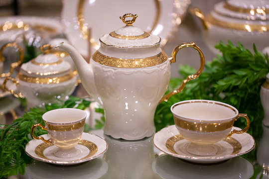 Arrangement of a luxury porcelain dinnerware with golden hand painted. Interior element
